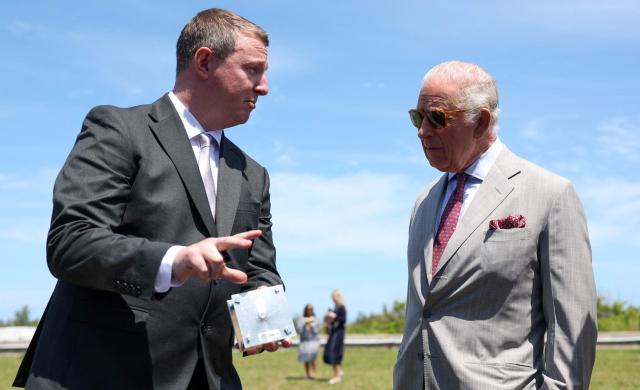 Britain's King Charles listens to Dan Terrett, co-founder of Odin Space, during a visit to a UK Space Agency (UKSA) site on Cooper's Island, Bermuda, May 2, 2026. King Charles III is in Bermuda for his first visit to a British Overseas Territory as Sovereign. (Photo by Suzanne Plunkett / POOL / AFP)
