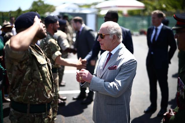 Britain's King Charles III presents an Operational Service Medal to members of the military at the Great Bay Coast Guard Station in St. David's, Bermuda, on May 2, 2026. King Charles III is in Bermuda for his first visit to a British Overseas Territory as Sovereign. (Photo by Henry NICHOLLS / AFP)