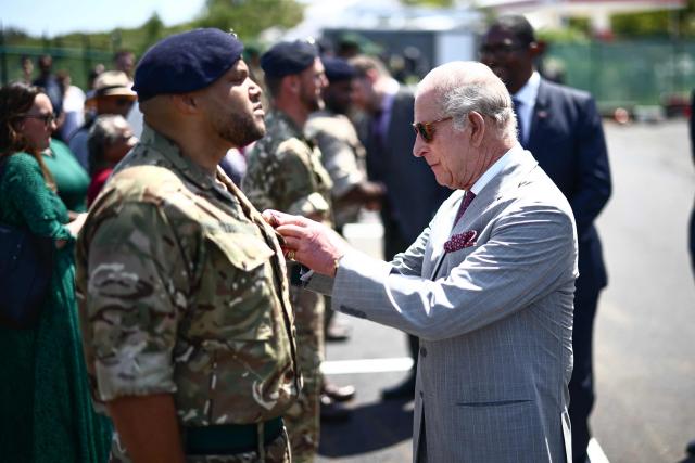 Britain's King Charles III presents an Operational Service Medal to members of the military at the Great Bay Coast Guard Station in St. David's, Bermuda, on May 2, 2026. King Charles III is in Bermuda for his first visit to a British Overseas Territory as Sovereign. (Photo by Henry NICHOLLS / AFP)