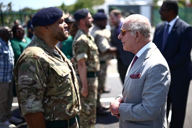Britain's King Charles III presents an Operational Service Medal to members of the military at the Great Bay Coast Guard Station in St. David's, Bermuda, on May 2, 2026. King Charles III is in Bermuda for his first visit to a British Overseas Territory as Sovereign. (Photo by Henry NICHOLLS / AFP)