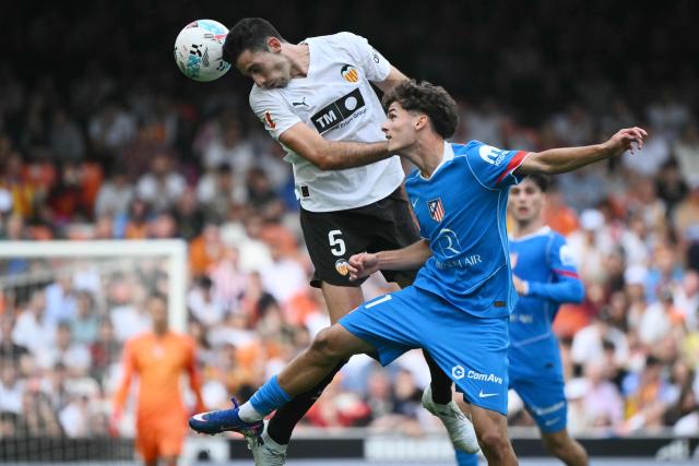 Valencia's Spanish defender #05 Cesar Tarrega wins a header over Atletico Madrid's Spanish midfielder #61 Miguel Cubo during the Spanish league football match between Valencia CF and Club Atletico de Madrid at Mestalla Stadium in Valencia on May 2, 2026. (Photo by JOSE JORDAN / AFP)