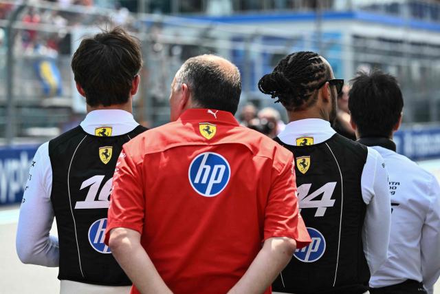 (L/R) Ferrari's Monegasque driver Charles Leclerc, Ferrari's French team principal Frederic Vasseur, and Ferrari's British driver Lewis Hamilton stand together on the starting grid before the start of the 2026 Miami Formula One Sprint at Miami International Autodrome in Miami Gardens, Florida, on May 2, 2026. (Photo by CHANDAN KHANNA / AFP)