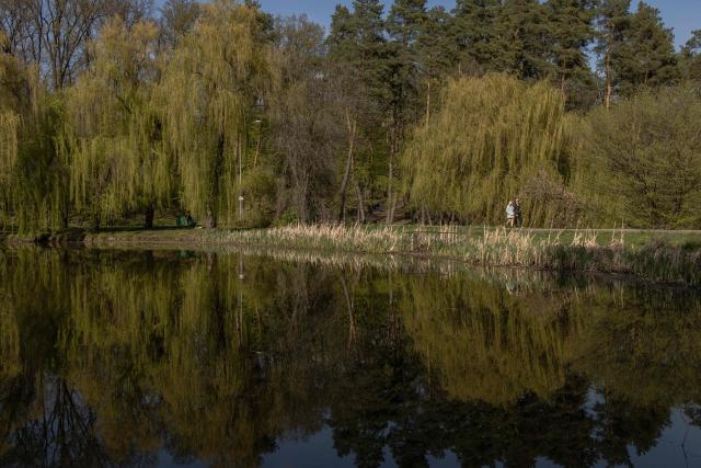 People walk through a park on a sunny day in Kyiv, on May 2, 2026, amid the Russian invasion of Ukraine. (Photo by Roman PILIPEY / AFP)