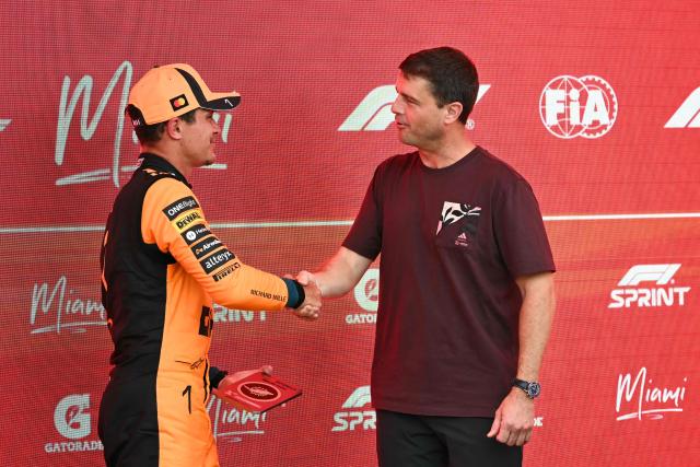 McLaren's British driver Lando Norris (L) shakes hands with US astronaut Reid Wiseman after Norris won the 2026 Miami Formula One Sprint at Miami International Autodrome in Miami Gardens, Florida, on May 2, 2026. (Photo by CHANDAN KHANNA / AFP)