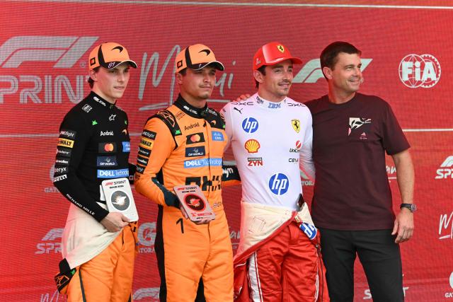 (L/R) McLaren's Australian driver Oscar Piastri (2nd place), McLaren's British driver Lando Norris (1st place), Ferrari's Monegasque driver Charles Leclerc (3rd place), and US astronaut Reid Wiseman stand together after the 2026 Miami Formula One Sprint at Miami International Autodrome in Miami Gardens, Florida, on May 2, 2026. (Photo by CHANDAN KHANNA / AFP)