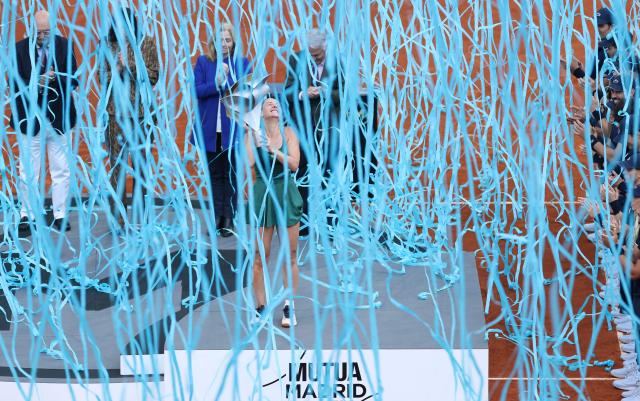 Ukraine's Marta Kostyuk celebrates on the podium after beating Russia's Mirra Andreeva during the 2026 WTA Tour Madrid Open tennis tournament final singles match at the Caja Magica in Madrid, on May 2, 2026. (Photo by Thomas COEX / AFP)