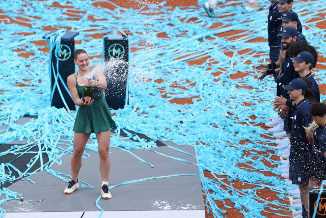 Ukraine's Marta Kostyuk celebrates on the podium after beating Russia's Mirra Andreeva during the 2026 WTA Tour Madrid Open tennis tournament final singles match at the Caja Magica in Madrid, on May 2, 2026. (Photo by Thomas COEX / AFP)