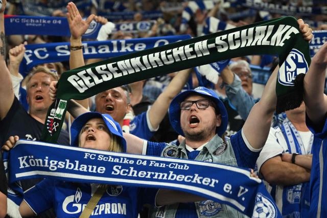 Schalke fans display their scarves prior to  the German second division Bundesliga football match between FC Schalke 04 and Fortuna Duesseldorf at the Veltins Arena in Gelsenkirchen, western Germany on May 2, 2026. Schalke are pushing to return to the first division next season with a win against Fortuna Duesseldorf on May 2, 2026. (Photo by INA FASSBENDER / AFP) / DFL REGULATIONS PROHIBIT ANY USE OF PHOTOGRAPHS AS IMAGE SEQUENCES AND/OR QUASI-VIDEO  ALTERNATIVE CROP