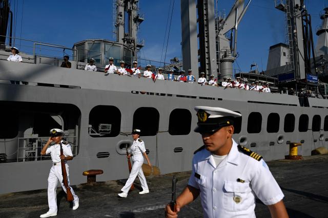 Members of the Taiwanese navy flutter Taiwanese and Guatemalan flags onboard one of three Taiwanese Navy warships as others walk next to them after their arrival at Puerto Quetzal, Guatemala on May 2, 2026, as part of a naval squadron. The three vessels -- described as being on a training mission -- powered into Puerto Quetzal, a port town on Guatemala's Pacific coast, in a visit "to strengthen the ties of friendship," Guatemalan officials and Taiwanese diplomats said. (Photo by Johan ORDONEZ / AFP)