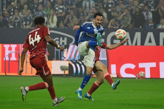 Schalke's Turkish midfielder #19 Kenan Karaman (R) scores the opening goal next to Fortuna Duesseldorf's German defender #44 Elias Egouli during the German second division Bundesliga football match between FC Schalke 04 and Fortuna Duesseldorf at the Veltins Arena in Gelsenkirchen, western Germany on May 2, 2026. Schalke are pushing to return to the first division next season with a win against Fortuna Duesseldorf on May 2, 2026. (Photo by INA FASSBENDER / AFP) / DFL REGULATIONS PROHIBIT ANY USE OF PHOTOGRAPHS AS IMAGE SEQUENCES AND/OR QUASI-VIDEO