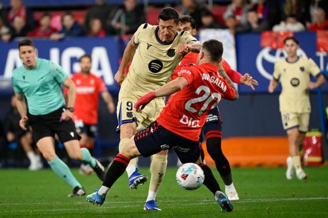 Barcelona's Polish forward #09 Robert Lewandowski is challenged by Osasuna's Spanish midfielder #20 Javi Galan during the Spanish league football match between CA Osasuna and FC Barcelona at El Sadar Stadium in Pamplona on May 2, 2026. (Photo by ANDER GILLENEA / AFP)