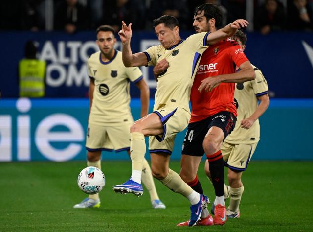 Osasuna's Spanish defender #24 Alejandro Catena (R) and Barcelona's Polish forward #09 Robert Lewandowski fight for the ball during the Spanish league football match between CA Osasuna and FC Barcelona at El Sadar Stadium in Pamplona on May 2, 2026. (Photo by ANDER GILLENEA / AFP)
