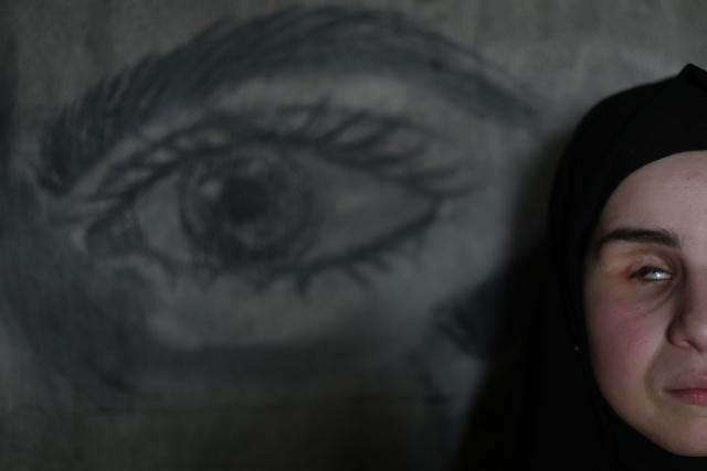 Areej al-Saafin, who lost her eye as a result of an Israeli military strike, uses charcoal to draw on the wall of her home in the Bureij Palestinian refugee camp in the central Gaza Strip on May 2, 2026. The war on the Gaza Strip was sparked following the militant Palestinian group Hamas's October 7, 2023 attack on Israel, which resulted in the deaths of 1,221 people. Israel's retaliatory assault on Gaza has killed at least 72,600 people, according to figures from the health ministry that the UN considers reliable. with th  majority of Gaza's 2.4 million people being displaced. (Photo by Eyad Baba / AFP)