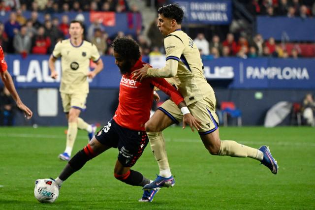 Osasuna's French defender #19 Valentin Rosier (L) and Barcelona's Portuguese defender #02 Joao Cancelo fight for the ball during the Spanish league football match between CA Osasuna and FC Barcelona at El Sadar Stadium in Pamplona on May 2, 2026. (Photo by ANDER GILLENEA / AFP)