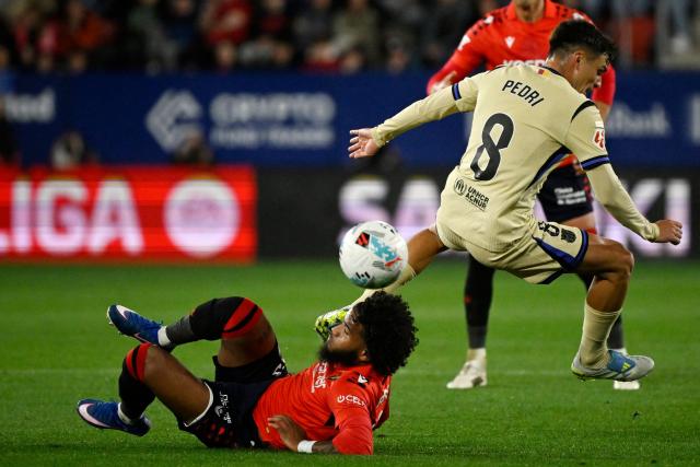 Osasuna's French defender #19 Valentin Rosier and Barcelona's Spanish midfielder #08 Pedri fight for the ball during the Spanish league football match between CA Osasuna and FC Barcelona at El Sadar Stadium in Pamplona on May 2, 2026. (Photo by ANDER GILLENEA / AFP)