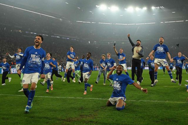Schalke's players and Schalke's Austrian head coach Miron Muslic (4th R) celebrate in front of their fans after the German second division Bundesliga football match between FC Schalke 04 and Fortuna Duesseldorf at the Veltins Arena in Gelsenkirchen, western Germany on May 2, 2026. Schalke will return to the first division next season after the win against Fortuna Duesseldorf on May 2, 2026. (Photo by INA FASSBENDER / AFP) / ALTERNATIVE CROP