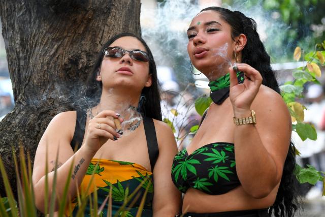 Two women smoke during the World Marijuana March in Medellin, Colombia, on May 2, 2026. (Photo by Jaime SALDARRIAGA / AFP)
