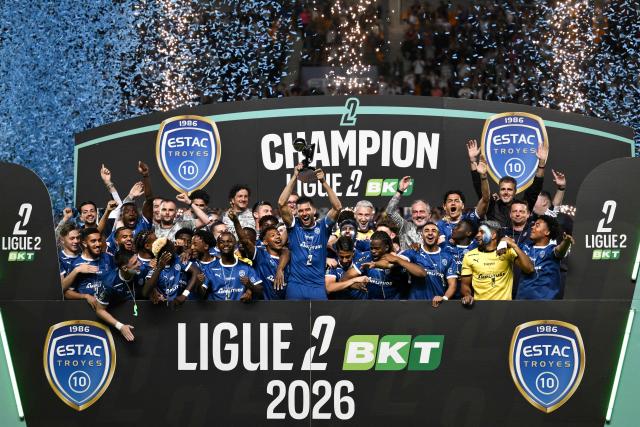 Troyes' players and staff celebrate with the French Ligue 2 championship trophy after winning the French L2 football match between Troyes and Laval at the stade de l'Aube in Troyes, eastern France, on May 2, 2026. (Photo by ARNAUD FINISTRE / AFP)