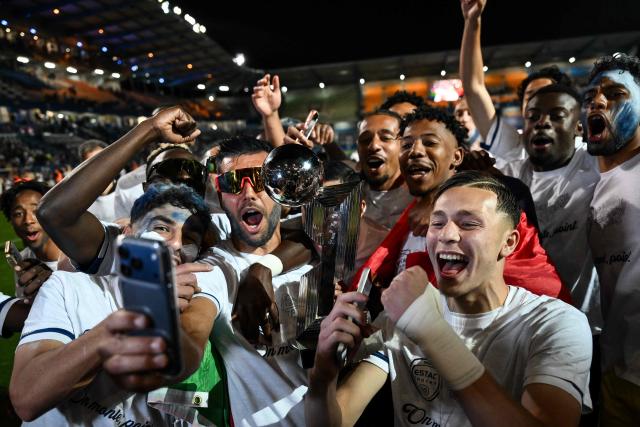 Troyes' players and supporters celebrate with the French Ligue 2 championship trophy after winning the French L2 football match between Troyes and Laval at the stade de l'Aube in Troyes, eastern France, on May 2, 2026. (Photo by ARNAUD FINISTRE / AFP)