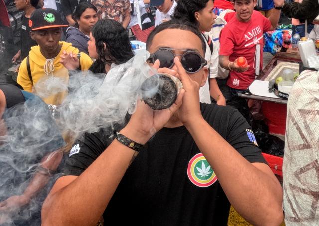 A man smokes a huge joint during the World Marijuana March in Medellin, Colombia, on May 2, 2026. (Photo by JOAQUIN SARMIENTO / AFP)