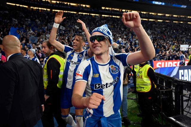 FC Porto's Polish midfielder #77 Oskar Pietuszewski (R) and teammates celebrate their Portuguese League's 31st title after winning the Portuguese League football match between FC Porto and FC Alverca at Dragao stadium in Porto, on May 2, 2026. Porto were crowned Portuguese champions with two games to spare after a 1-0 win over Alverca today. (Photo by Miguel RIOPA / AFP)