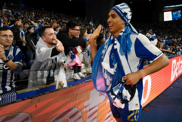 FC Porto's Portuguese defender #20 Alberto Oliveira Baio slaps hands with fans as they celebrate their Portuguese League's 31st title after winning the Portuguese League football match between FC Porto and FC Alverca at Dragao stadium in Porto, on May 2, 2026. Porto were crowned Portuguese champions with two games to spare after a 1-0 win over Alverca today. (Photo by Miguel RIOPA / AFP)