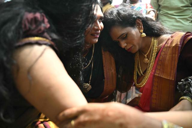This photograph taken on April 29, 2026 shows Thilothama (R), a member of the transgender community mourning after a priest cut the "thali", a sacred thread symbolising end of her marriage to Hindu warrior god Aravan during the annual Koovagam transgender festival at the Koothandavar temple in Tamil Nadu's Kallakurichi district. For a few fleeting days each year, at the heart of the Koothandavar Temple where ostracised transgender community members from across India come to honour the Hindu deity Aravan, a tradition rooted in millennia-old Hindu texts -- and to enjoy a brief oasis of freedom, for the past 10 years Thilothama has returned to Koovagam, where a beauty pageant and singing contests are held alongside religious rituals. (Photo by R.Satish BABU / AFP)