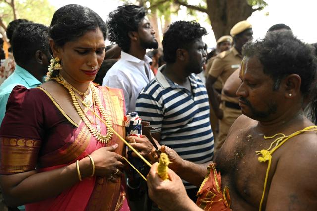 This photograph taken on April 29, 2026 shows Thilothama, a member of the transgender community mourning as a priest cuts "thali", a sacred thread symbolising end of her marriage to Hindu warrior god Aravan during the annual Koovagam transgender festival at the Koothandavar temple in Tamil Nadu's Kallakurichi district. For a few fleeting days each year, at the heart of the Koothandavar Temple where ostracised transgender community members from across India come to honour the Hindu deity Aravan, a tradition rooted in millennia-old Hindu texts -- and to enjoy a brief oasis of freedom, for the past 10 years Thilothama has returned to Koovagam, where a beauty pageant and singing contests are held alongside religious rituals. (Photo by R.Satish BABU / AFP)