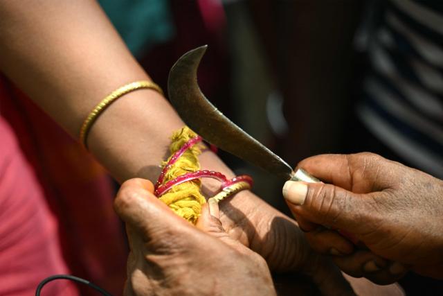 This photograph taken on April 29, 2026 shows Thilothama, a member of the transgender community getting her bangles broken by a priest symbolising end of her marriage to Hindu warrior god Aravan during the annual Koovagam transgender festival at the Koothandavar temple in Tamil Nadu's Kallakurichi district. For a few fleeting days each year, at the heart of the Koothandavar Temple where ostracised transgender community members from across India come to honour the Hindu deity Aravan, a tradition rooted in millennia-old Hindu texts -- and to enjoy a brief oasis of freedom, for the past 10 years Thilothama has returned to Koovagam, where a beauty pageant and singing contests are held alongside religious rituals. (Photo by R.Satish BABU / AFP)