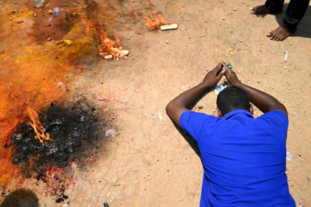 This photograph taken on April 29, 2026 shows a devotee offering prayers to a chariot procession of Hindu warrior god Aravan during the annual Koovagam transgender festival at the Koothandavar temple in Tamil Nadu's Kallakurichi district. For a few fleeting days each year, at the heart of the Koothandavar Temple where ostracised transgender community members from across India come to honour the Hindu deity Aravan, a tradition rooted in millennia-old Hindu texts -- and to enjoy a brief oasis of freedom. (Photo by R.Satish BABU / AFP)