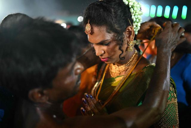 This photograph taken on April 28, 2026 shows a member of the transgender community getting "thali", a sacred thread tied to her neck symbolising her marriage to Hindu warrior god Aravan during the annual Koovagam transgender festival at the Koothandavar temple in Tamil Nadu's Kallakurichi district. For a few fleeting days each year, at the heart of the Koothandavar Temple where ostracised transgender community members from across India come to honour the Hindu deity Aravan, a tradition rooted in millennia-old Hindu texts -- and to enjoy a brief oasis of freedom. (Photo by R.Satish BABU / AFP)