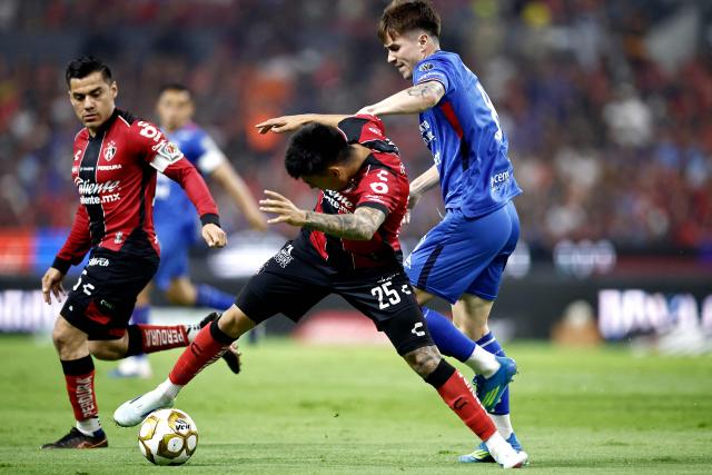 Atlas' forward #25 Jorge Rodriguez (C) and Cruz Azul's Argentine midfielder #08 Agustin Palavecino (R) fight for the ball during the Mexican League Clausura Tournament quarterfinal first leg football match between Atlas and Cruz Azul at the Jalisco stadium in Guadalajara, Jalisco state, Mexico on May 2, 2026. (Photo by Ulises RUIZ / AFP)