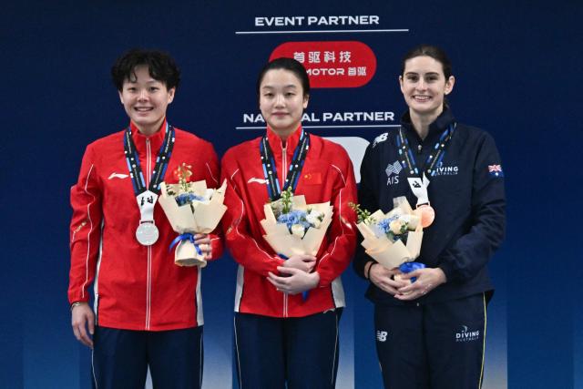 Gold medalist China’s Chen Jia (C) celebrates with silver medalist Chinaґs Chen Yiwen (L) and broze medalist Australiaґs Maddison Keeney after the women’s 3m springboard event at the World Aquatics Diving World Cup Super Finals in Beijing on May 3, 2026. (Photo by Pedro PARDO / AFP)