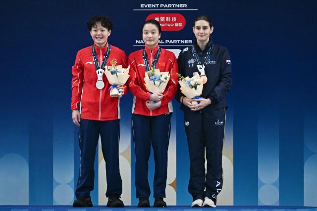 Gold medalist China’s Chen Jia (C) celebrates with silver medalist Chinaґs Chen Yiwen (L) and broze medalist Australiaґs Maddison Keeney after the women’s 3m springboard event at the World Aquatics Diving World Cup Super Finals in Beijing on May 3, 2026. (Photo by Pedro Pardo / AFP)