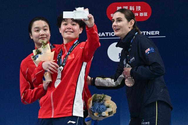 Gold medalist China’s Chen Jia (L) celebrates with silver medalist Chinaґs Chen Yiwen (C) and broze medalist Australiaґs Maddison Keeney after the women’s 3m springboard event at the World Aquatics Diving World Cup Super Finals in Beijing on May 3, 2026. (Photo by Pedro PARDO / AFP)