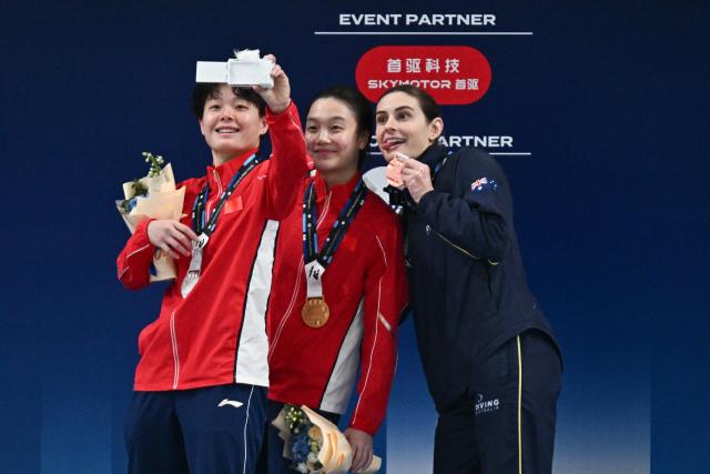 Gold medalist China’s Chen Jia (C) celebrates with silver medalist Chinaґs Chen Yiwen (L) and broze medalist Australiaґs Maddison Keeney after the women’s 3m springboard event at the World Aquatics Diving World Cup Super Finals in Beijing on May 3, 2026. (Photo by Pedro PARDO / AFP)