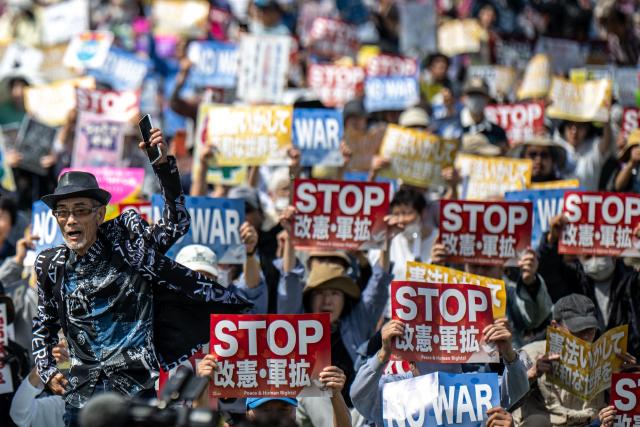 People hold placards reading “No war” and “Stop constitutional revision, military expansion” during the Grand Constitution Rally 2026 to mark Constitution Memorial Day in Tokyo on May 3, 2026. (Photo by Philip FONG / AFP)
