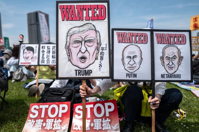 People display posters of Japan's Prime Minister Sanae Takaichi (L), US President Donald Trump (C), Russia's President Vladimir Putin (2nd R) and Israel's Prime Minister Benjamin Netanyahu (R) during the Grand Constitution Rally 2026 to mark Constitution Memorial Day in Tokyo on May 3, 2026. (Photo by Philip FONG / AFP)