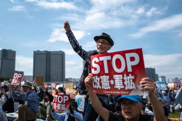 People hold placards reading “No war” and “Stop constitutional revision, military expansion” during the Grand Constitution Rally 2026 to mark Constitution Memorial Day in Tokyo on May 3, 2026. (Photo by Philip FONG / AFP)