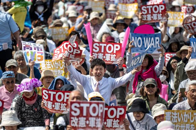 People hold placards reading “No war” and “Stop constitutional revision, military expansion” during the Grand Constitution Rally 2026 to mark Constitution Memorial Day in Tokyo on May 3, 2026. (Photo by Philip FONG / AFP)