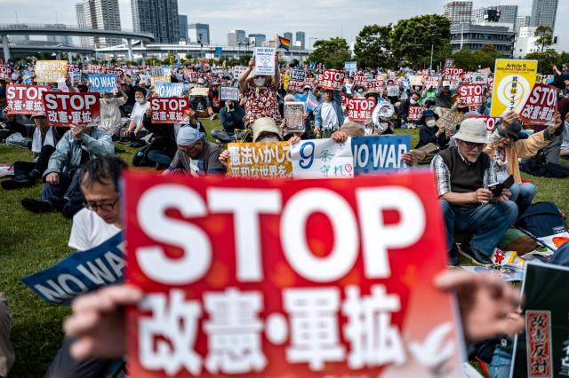 People hold placards reading “No war” and “Stop constitutional revision, military expansion” during the Grand Constitution Rally 2026 to mark Constitution Memorial Day in Tokyo on May 3, 2026. (Photo by Philip FONG / AFP)