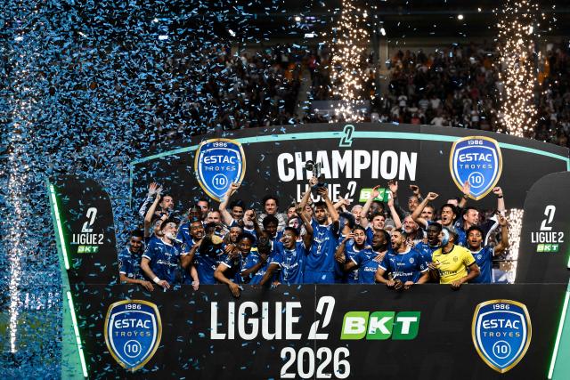 Troyes' players and staff celebrate with the French Ligue 2 championship trophy after winning the French L2 football match between Troyes and Laval at the stade de l'Aube in Troyes, eastern France, on May 2, 2026. (Photo by ARNAUD FINISTRE / AFP)