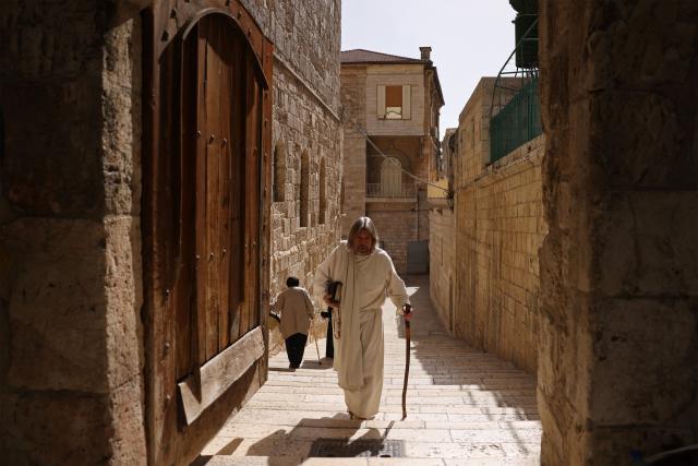 A pilgrim walks outside the Church of the Holy Sepulchre in the old city of Jerusalem on May 3, 2026. (Photo by HAZEM BADER / AFP)