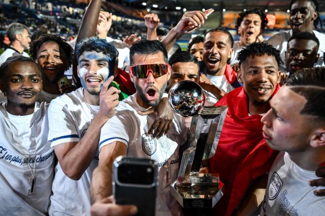 Troyes' players celebrate with the French Ligue 2 championship trophy after winning the French L2 football match between Troyes and Laval at the stade de l'Aube in Troyes, eastern France, on May 2, 2026. (Photo by ARNAUD FINISTRE / AFP)