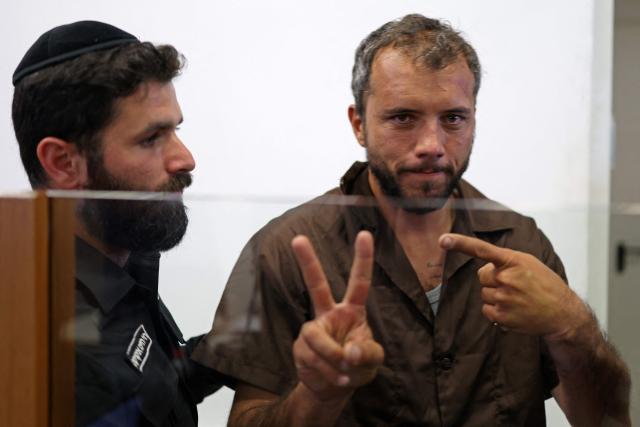 Brazilian activist Thiago Avila gestures upon his arrival at a court in Ashkelon on May 3, 2026. Two foreign activists from a Gaza-bound flotilla who were brought to Israel for interrogation appeared before an Israeli court on May 3, a rights group defending them told AFP. The flotilla of more than 50 vessels had set sail from France, Spain and Italy with the aim of breaking an Israeli blockade of Gaza and bringing supplies to the devastated Palestinian territory. (Photo by Ilia YEFIMOVICH / AFP)