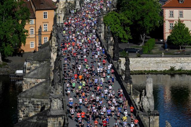 Participants run across the Charles Bridge during the Prague marathon on May 3, 2026 in Prague, Czech Republic. (Photo by Michal Cizek / AFP)