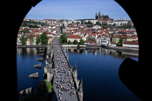 Participants run across the Charles Bridge during the Prague marathon on May 3, 2026 in Prague, Czech Republic. (Photo by Michal Cizek / AFP)