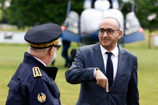 France's Interior Minister Laurent Nunez (R) speaks with Cher Prefect Philippe Le Moing Surzur as he arrives after flying over the site of a "teknival" rave party at a military site in Cornusse, near Bourges, central France on May 3, 2026. Between 17,000 and 40,000 people participate in the free party which has been taking place, without major incident, since May 1, 2026. The gathering comes as the French parliament is seeking to tighten legislation against unauthorised rave parties, introducing prison sentences for organisers and fines for attendees. (Photo by Kenzo TRIBOUILLARD / AFP)