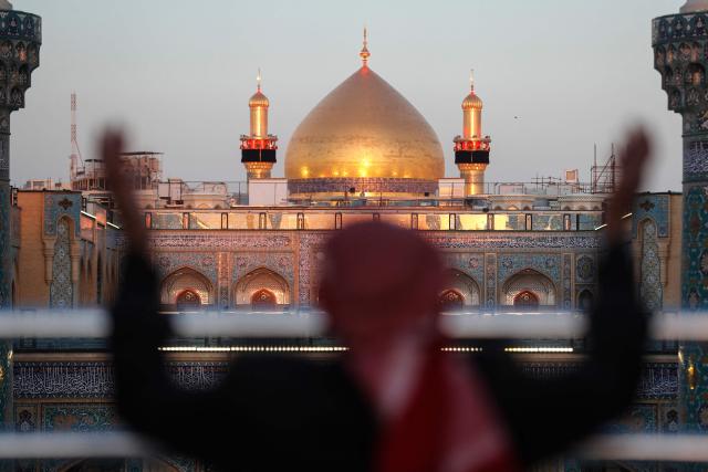 (FILES) A Shia Muslim man gestures while visiting the Imam Ali Shrine during the fasting month of Ramadan in Najaf on March 10, 2026, on the anniversary of the death of Ali bin Abi Taleb, the cousin, son-in-law and companion of the Prophet Muhammad. In Iraq's holy city of Najaf, the majestic shrine of Imam Ali stands quieter than usual, its vast courtyards no longer filled with pilgrims whose whispers once echoed, melding in different languages. Typically, millions of Shia Muslims from around the world flock to Iraq's holy cities of Najaf and Karbala every year. But the Middle East war, ignited by a joint US-Israeli attack on Iran on February 28, has stemmed the usual influx of pilgrims from Iran, Lebanon, Gulf states, India, Afghanistan and elsewhere. (Photo by AHMAD AL-RUBAYE / AFP)