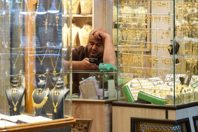 (FILES) A shop owner waits for custormers in the Old City of Najaf on April 22, 2026. In Iraq's holy city of Najaf, the majestic shrine of Imam Ali stands quieter than usual, its vast courtyards no longer filled with pilgrims whose whispers once echoed, melding in different languages. In nearby markets, shopkeepers and hotel owners have little to do. Their days drag on as they hope for tourists to come through their doors and revive their businesses. (Photo by Qassem al-KAABI / AFP)